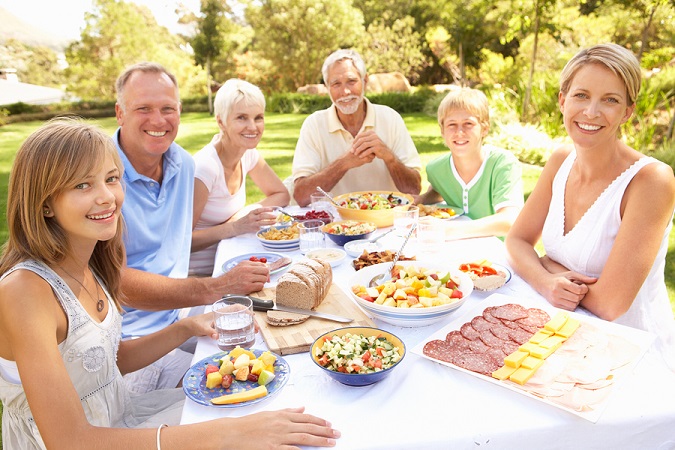 Extended Family Enjoying Meal In Garden