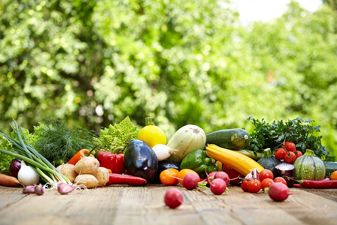 Fresh organic vegetables ane fruits on wood table  in the garden