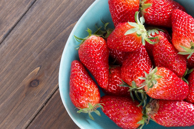 close up of strawberry on wooden background