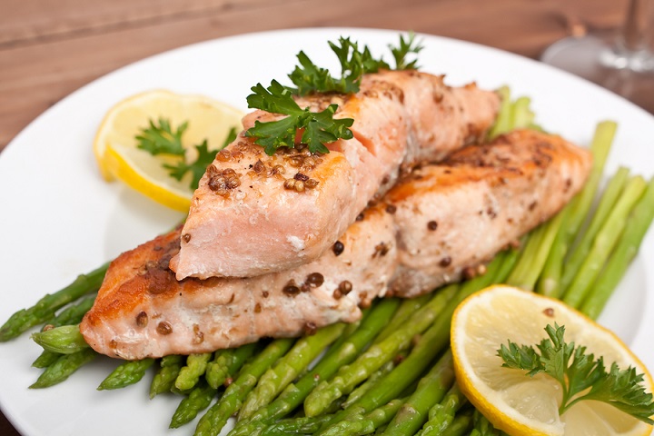 healthy salmon with coriander garnished with asparagus and lemon